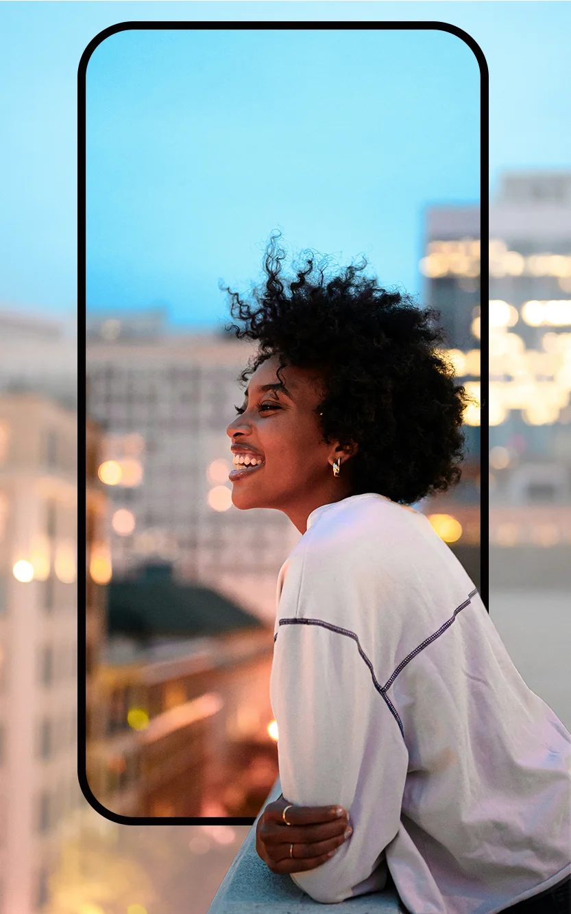 Une apprenante Vosa, souriante, sur un toit au crépuscule